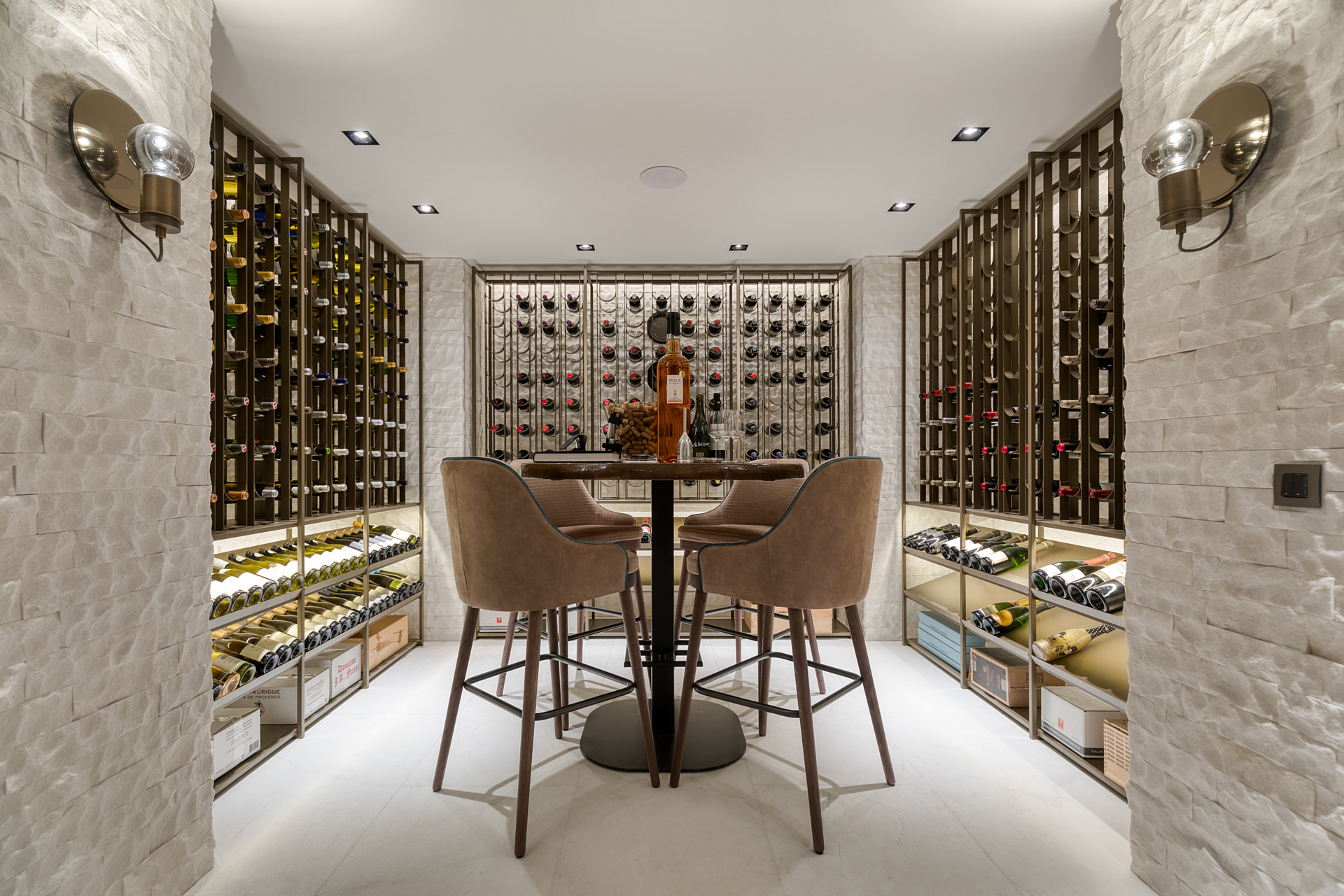 Wine cellar with cast floor and custom brazen cooled wine racks surrounded by white stone