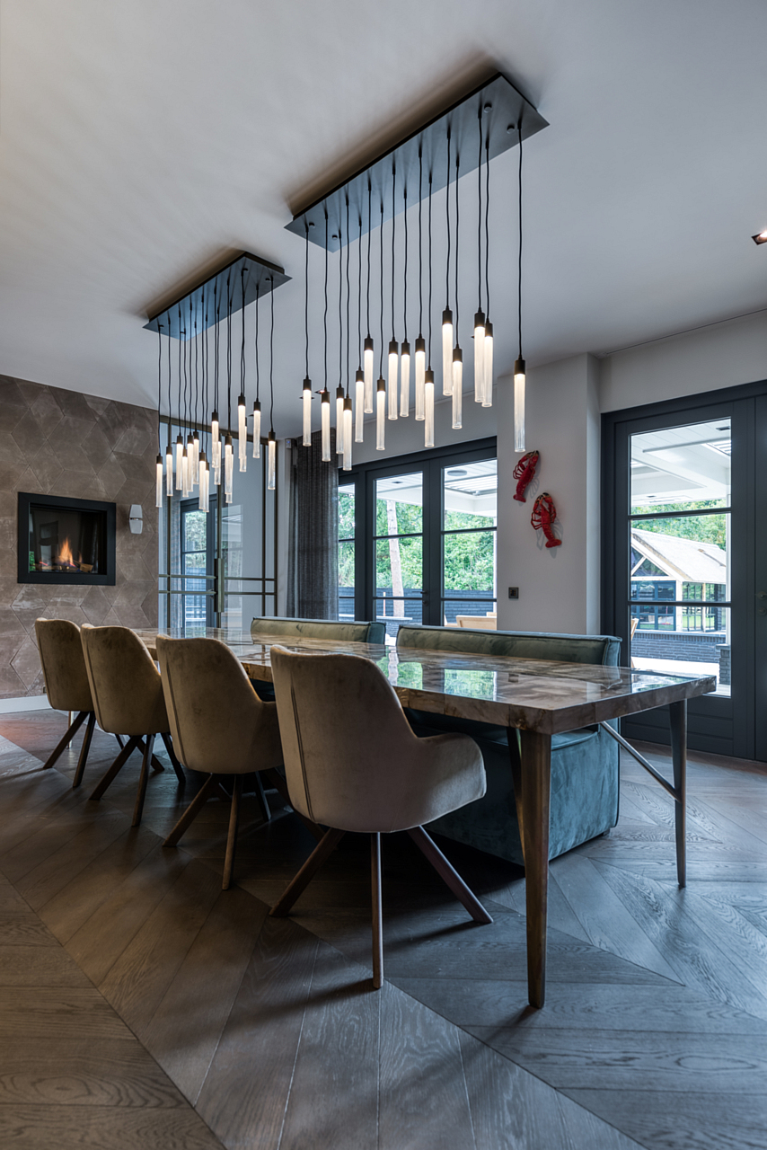 Petrified wood dining table with brass frame and overhanging chandelier