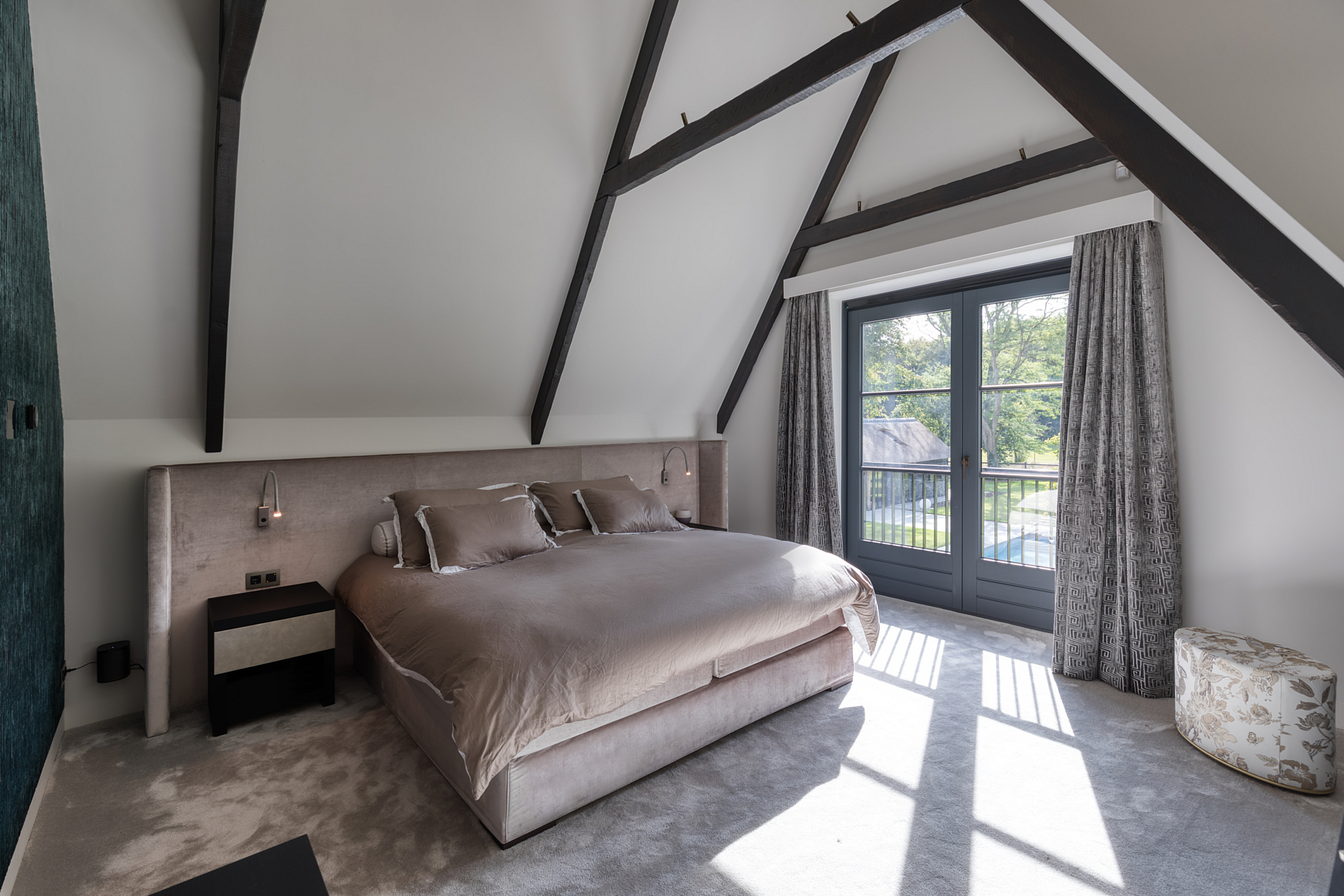 Master bedroom in biege with balcony and overhanging rafters