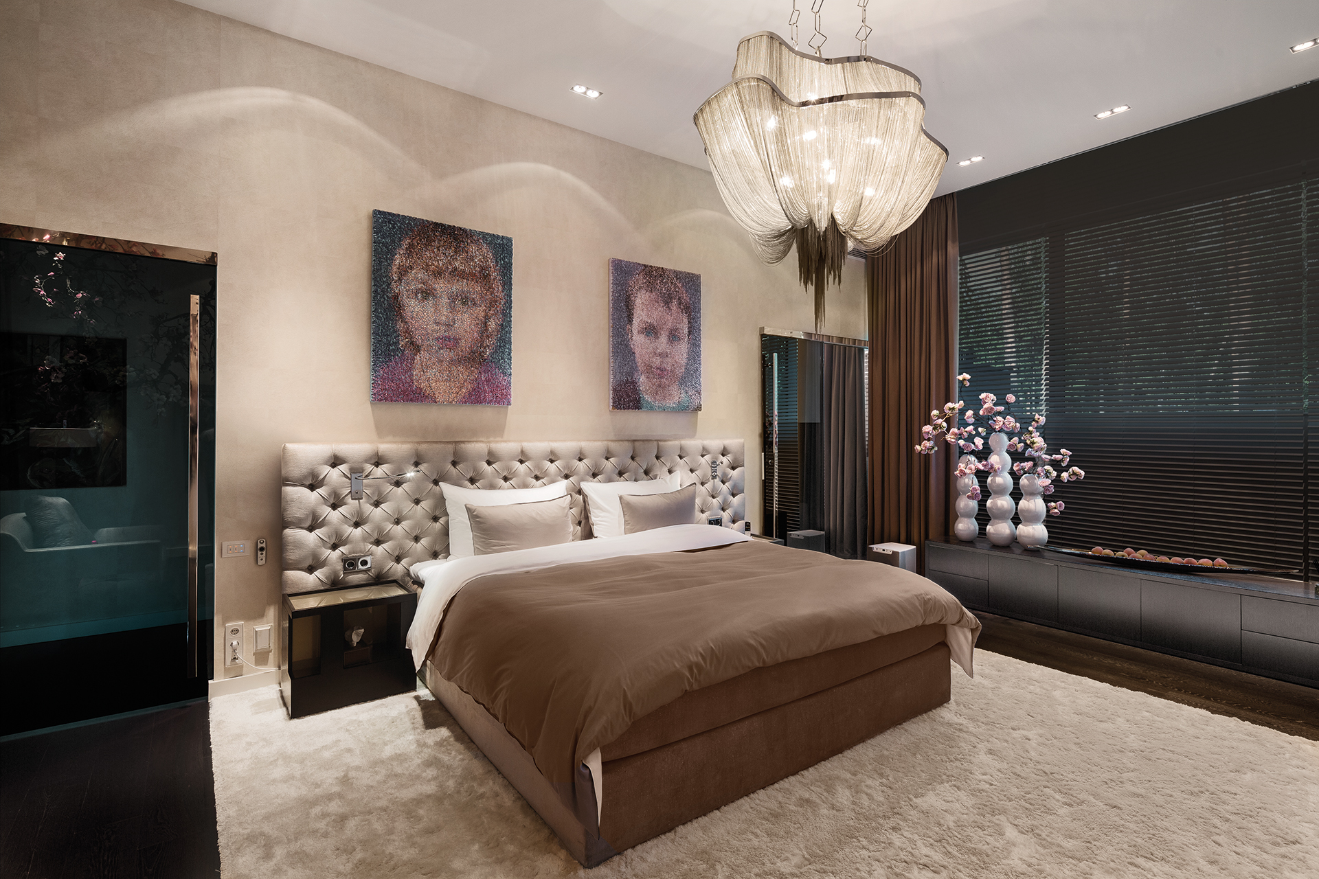 Master bedroom featuring a bed with headboard, a fabric draped chandelier and specially made artwork