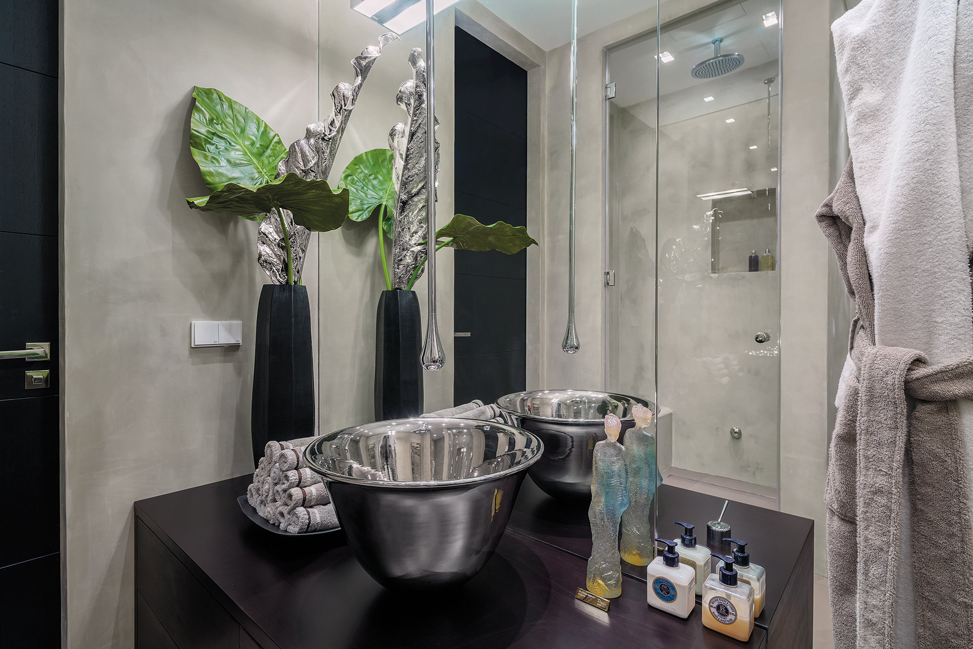 Sink with ceiling mounted silver spout infront of the shower with ceiling high mirrors