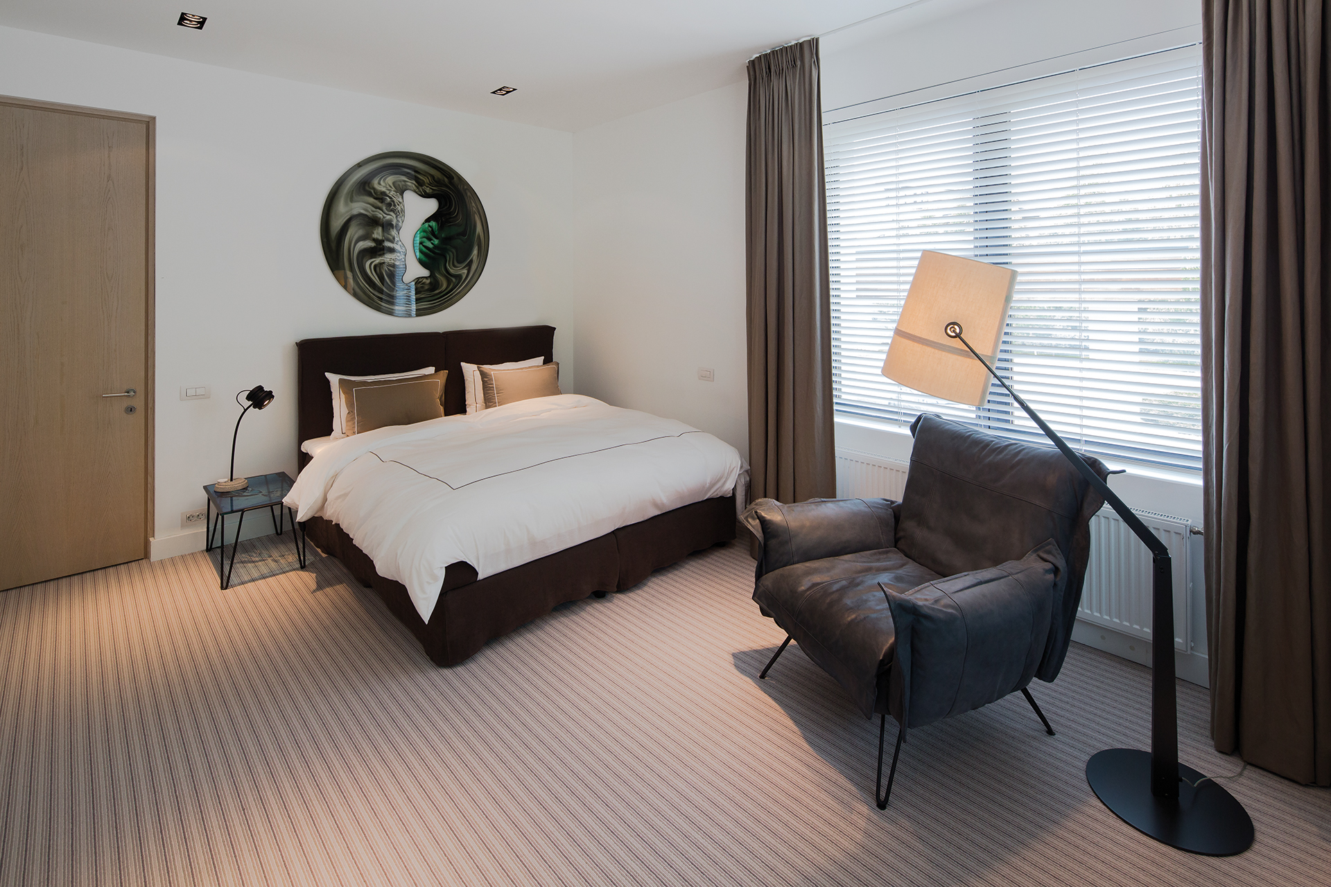 Guestroom with corner bed and reading chair